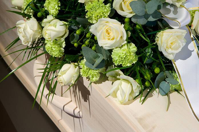 A coffin with a flower arrangement in a morgue