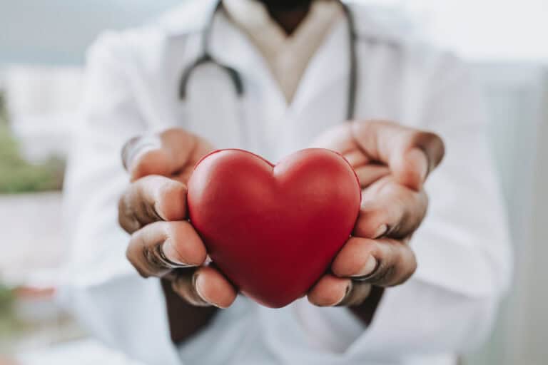 Portrait of a doctor holding a heart in his hands
